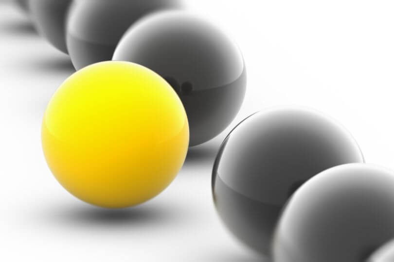 a yellow ball stands out with black balls